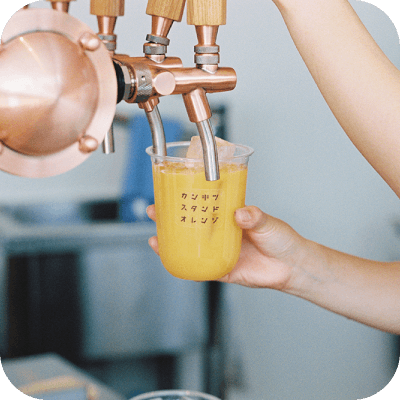 オレンジジュースを注ぐ店員